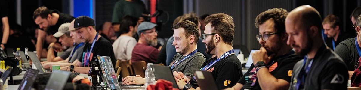 TYPO3 DevDays Coding Night. Menschen beim Entwickeln in einem Raum